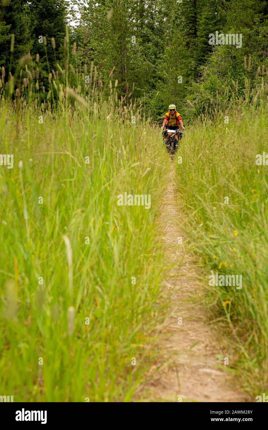 MT0047100...MONTANA Tom Kirkendall riding the narrow, grassy trail