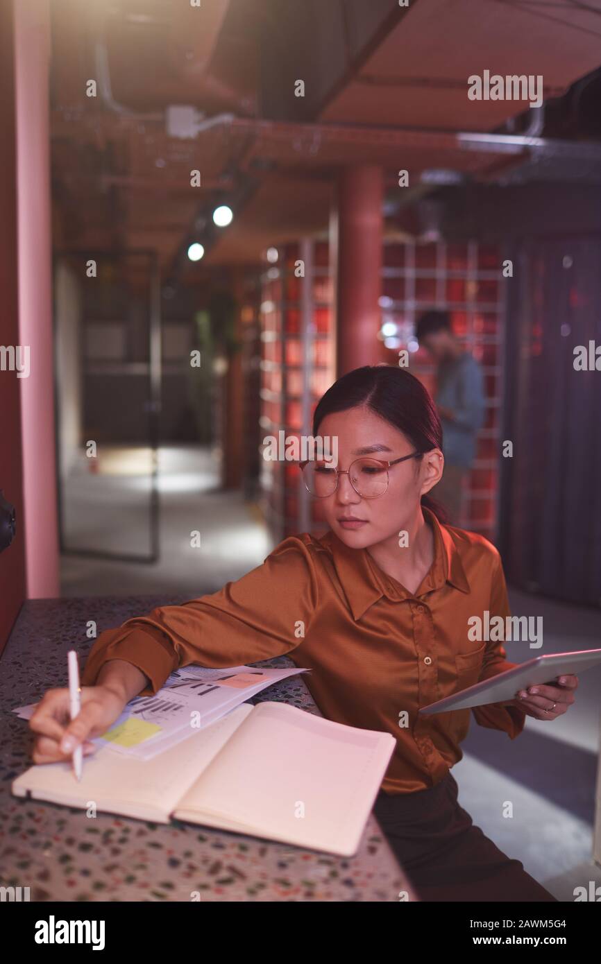 Portrait of contemporary Asian businesswoman working in futuristic office interior, copy space Stock Photo