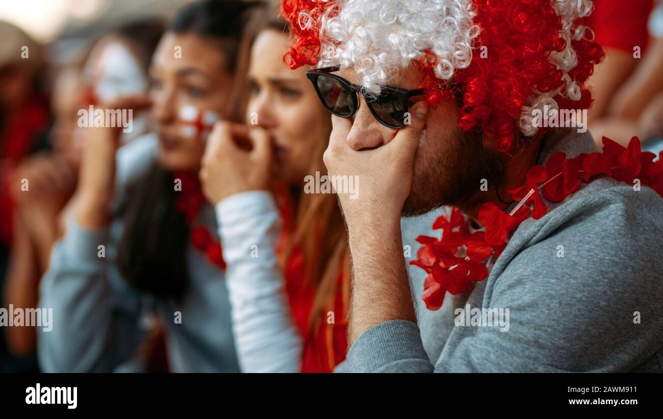 Group of supporters crying for the disqualification of their football team. Unhappy and frustrated fans at the stadium. Stock Photo