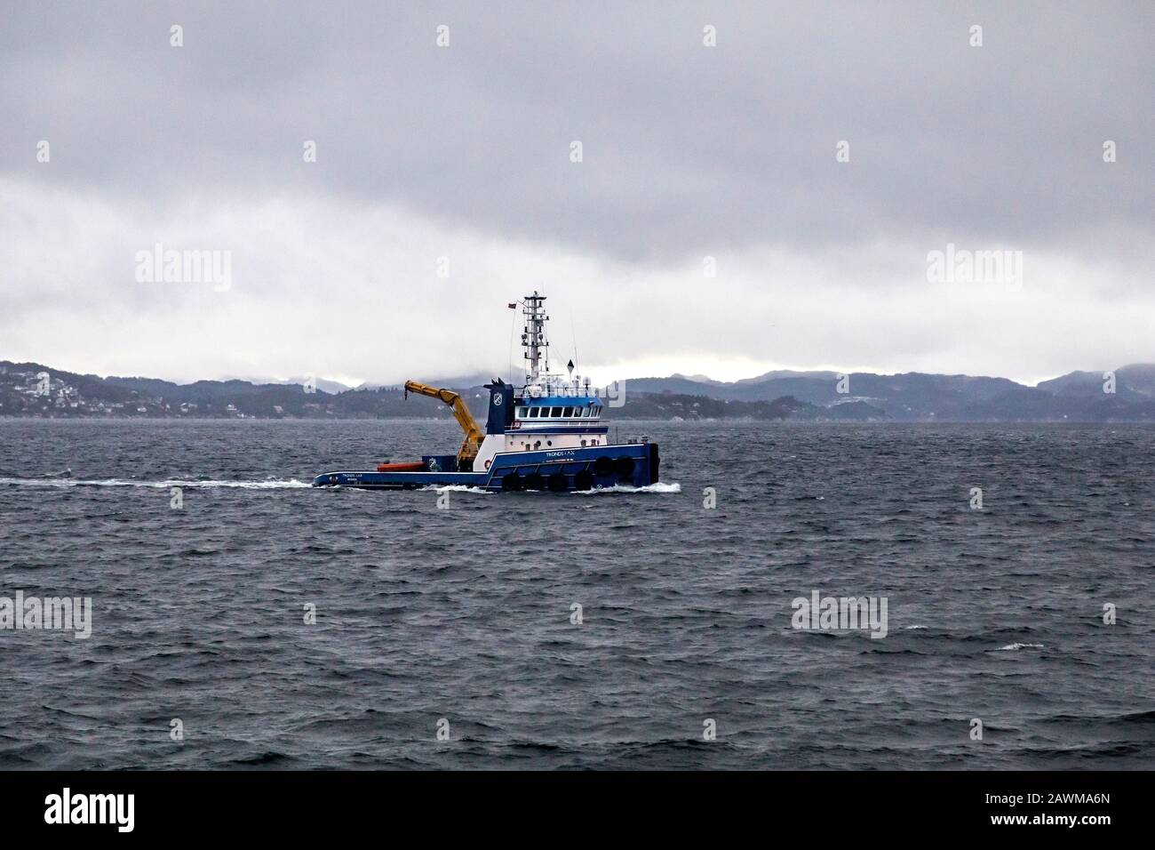 Tug boat Tronds Lax at Byfjorden, outside port of Bergen, Norway. A dark, rainy and foggy winter day Stock Photo