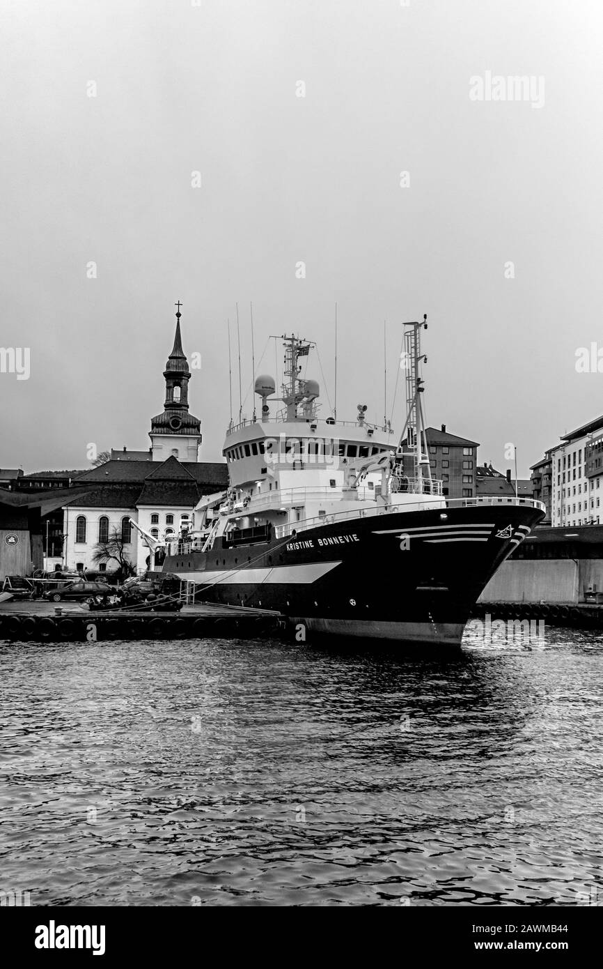 Ocean research vessel Kristine Bonnevie in the port of Bergen, Norway. Owned by the University of Bergen, Institute of Marine Research. Nykirken churc Stock Photo