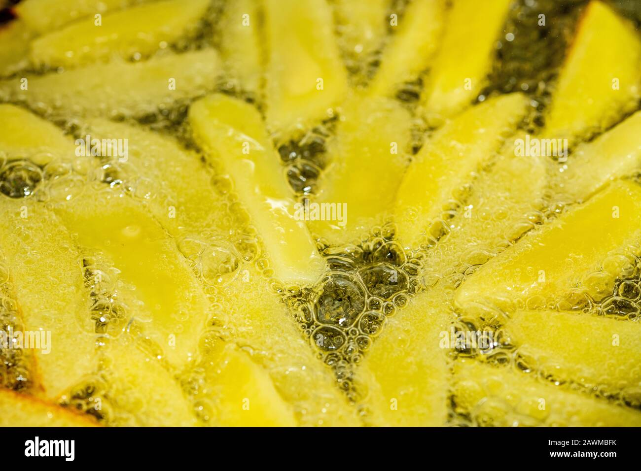 French fries frying in vegetable oil in the pan on the cooker Stock
