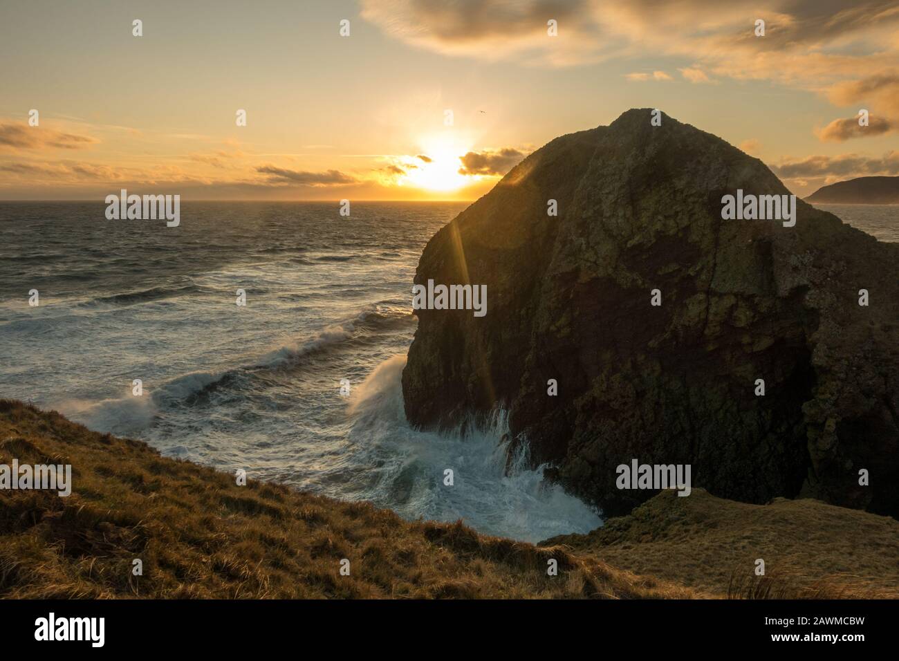 Roaring Cove at Dunaverty Castle and Dunaverty Rock with views behind of the Mull of Kintyre at sunset, Scotland Stock Photo