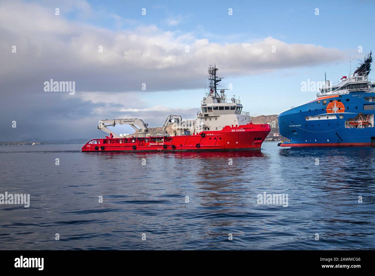 Offshore supply AHTS vessel BB Ocean arriving the port of Bergen, Norway. Meeting a much larger offshore supply vessel, the Horizon Arctic. A rainy, d Stock Photo