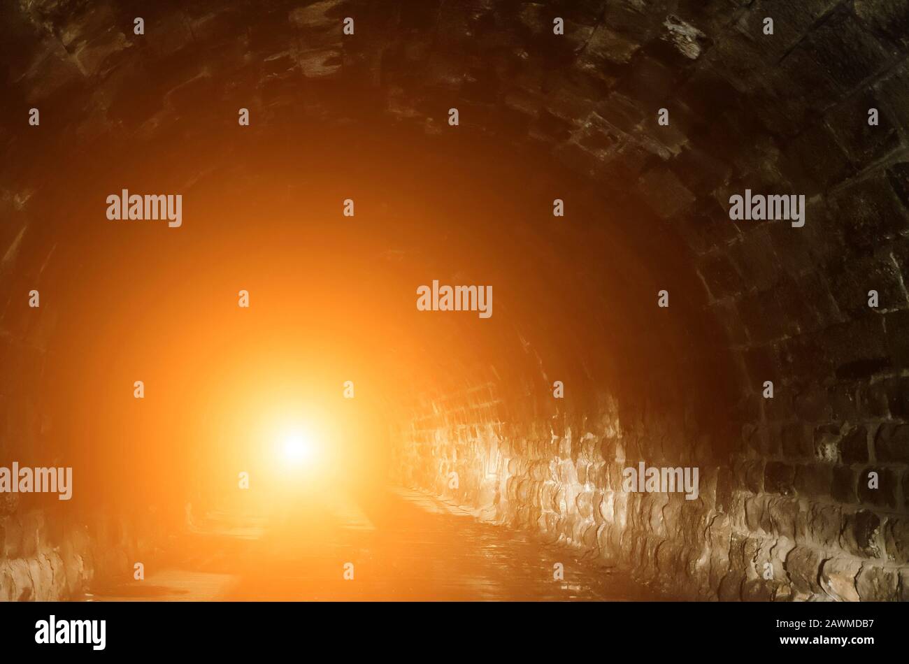 Orange light at the end of a tunnel Stock Photo