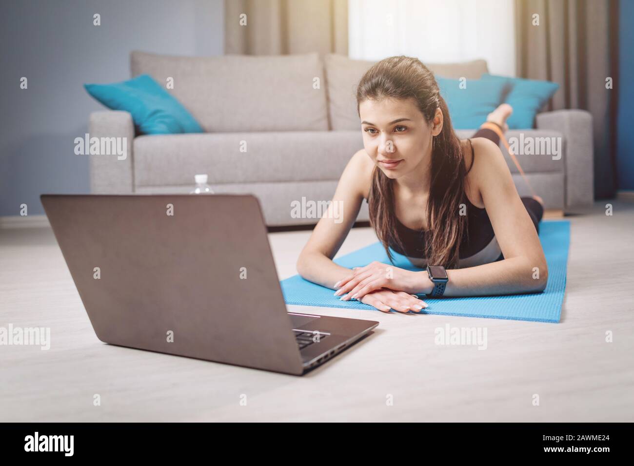 Brunette Making Physical Exercises According to Internet Guide Stock Photo