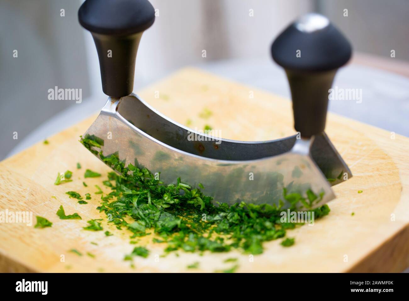https://c8.alamy.com/comp/2AWMF0K/parsley-on-a-wooden-chopping-board-that-has-been-chopped-with-a-herb-cutter-england-uk-gb-2AWMF0K.jpg