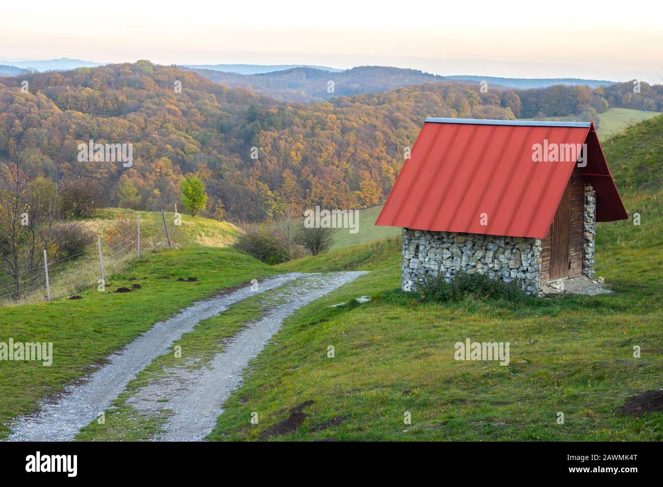 little hut with red roof and dirt road in beautiful forest landscape Stock Photo