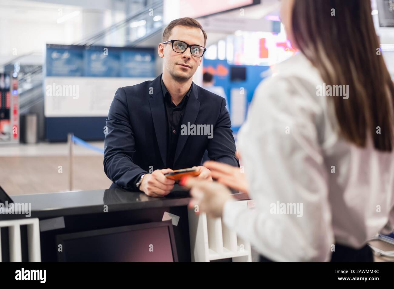 handsome businessman handing over air ticket at airline check in counter. Stock Photo