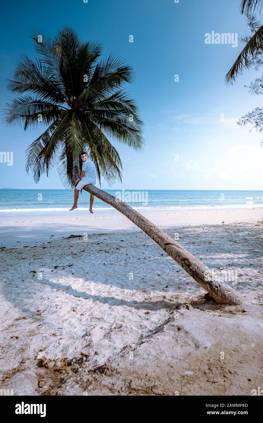 Thung Wua Laen beach Chumphon Thailand, men on the beach by palm tree hanging on the white beach  Stock Photo