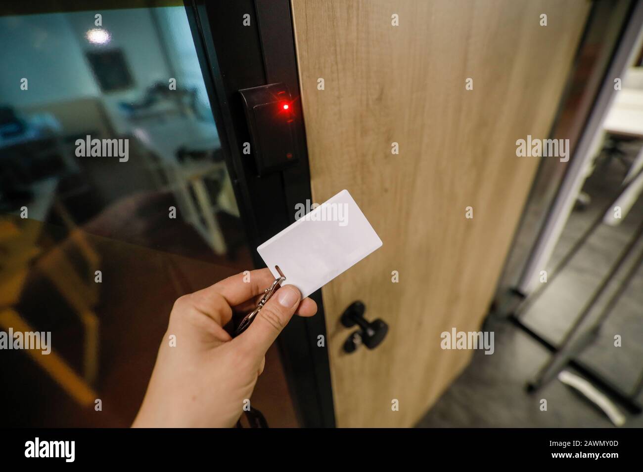 Shallow depth of field (selective focus) image with the hand of a man holding an access card inside an office building. Stock Photo
