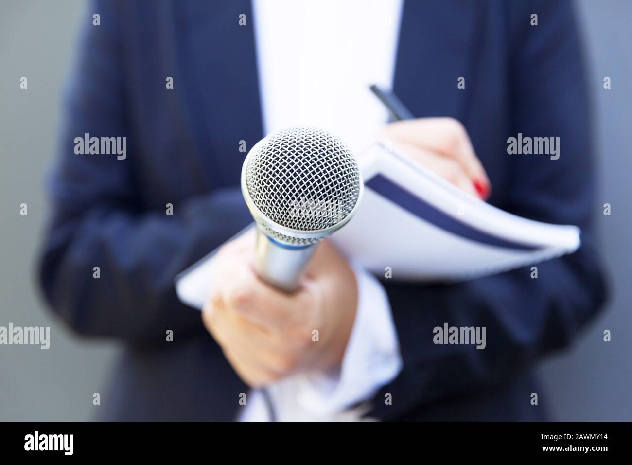 Female Reporter At Press Conference, Writing Notes, Holding Microphone ...