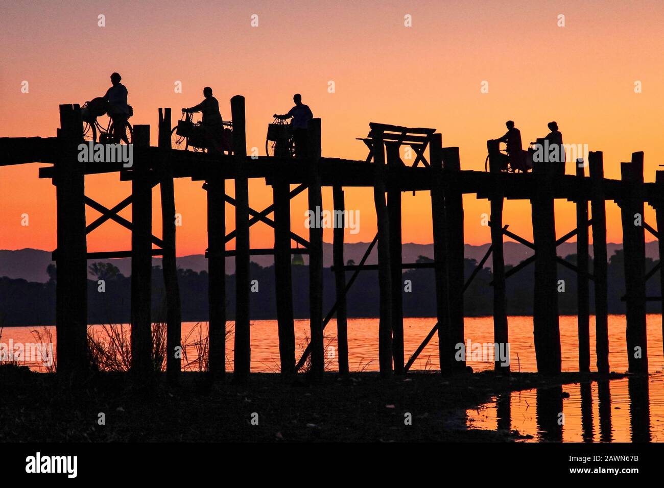 Silhouette of U Bein Bridge at sunrise. It is a crossing that spans ...