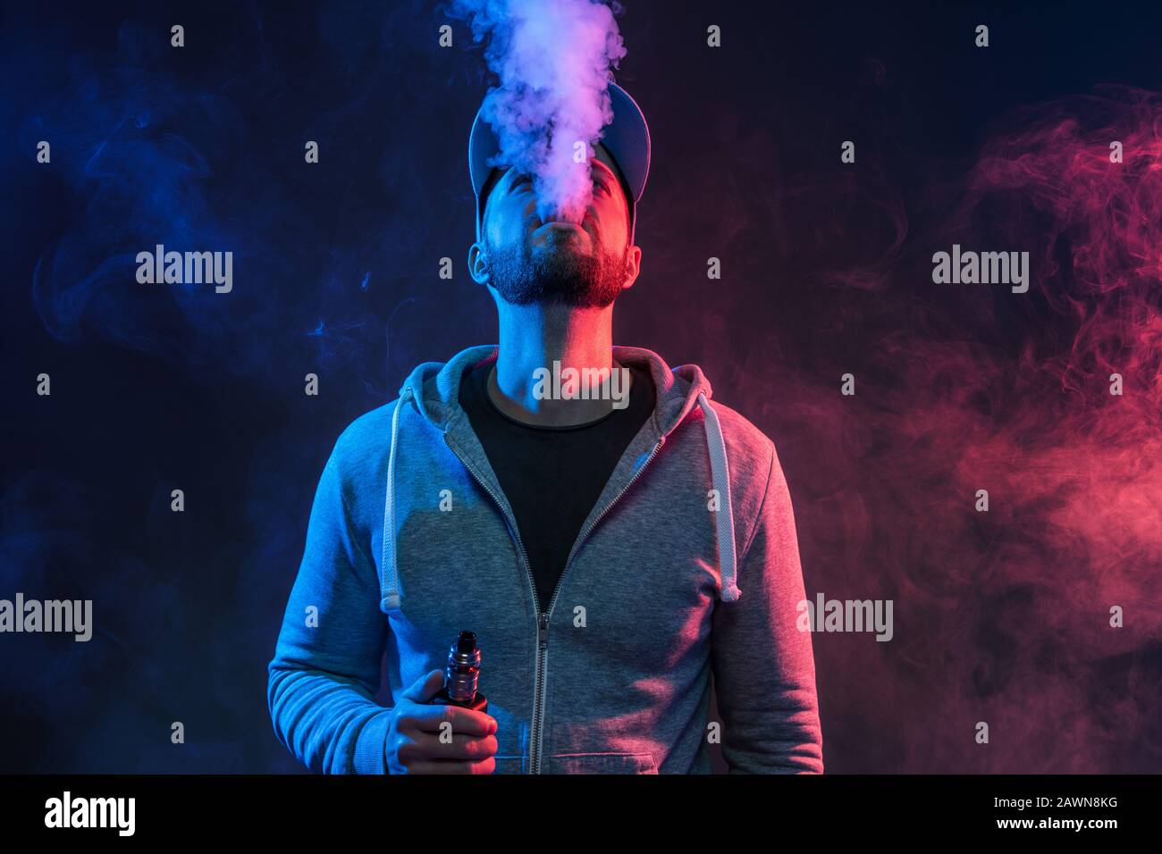 Vaping flavored e-liquid from an electronic cigarette Stock Photo