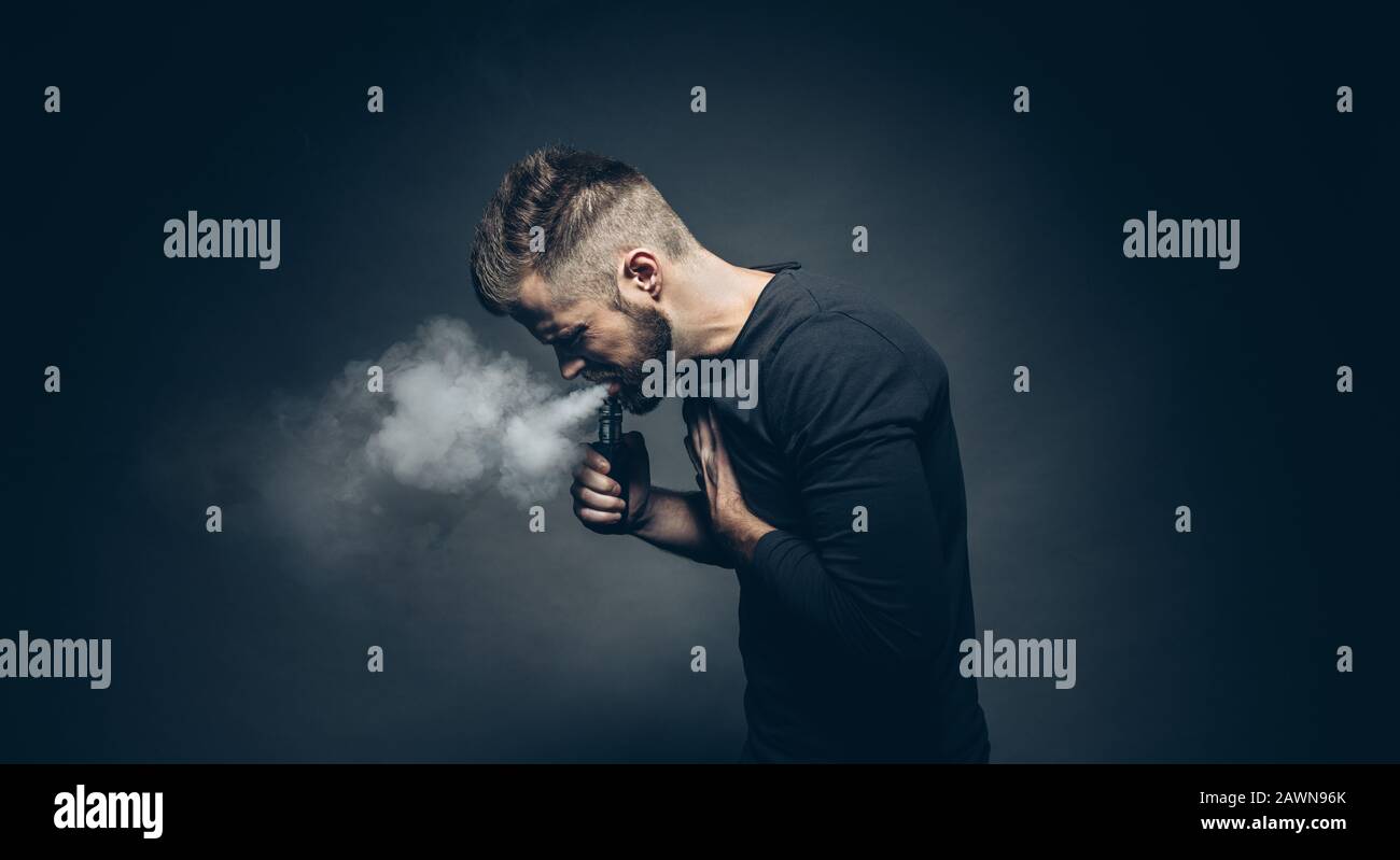 Vaping flavored e-liquid from an electronic cigarette Stock Photo