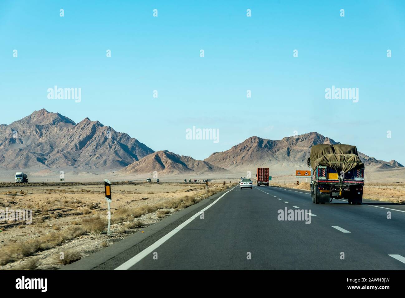 Road view with private cars and trucks between Kerman and Yazd, Iran Stock Photo