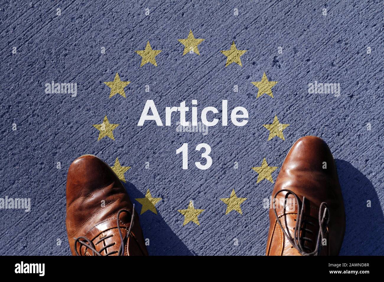 Man standing next to Article 13 written on the ground surrounded by the stars of the European Union Stock Photo