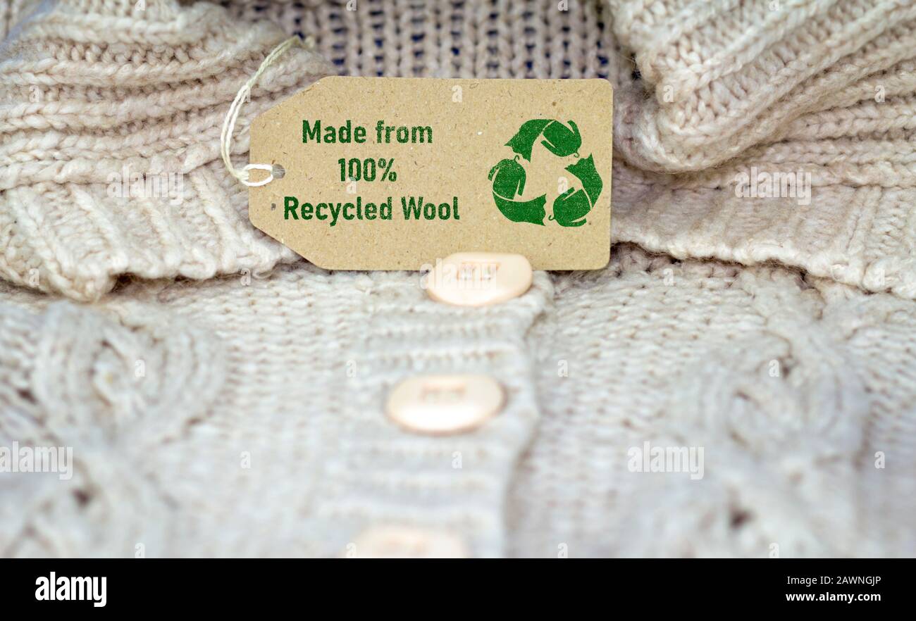 recycle wool text and recycle reuse symbol on wool jumper tag, sustainable zero waste living