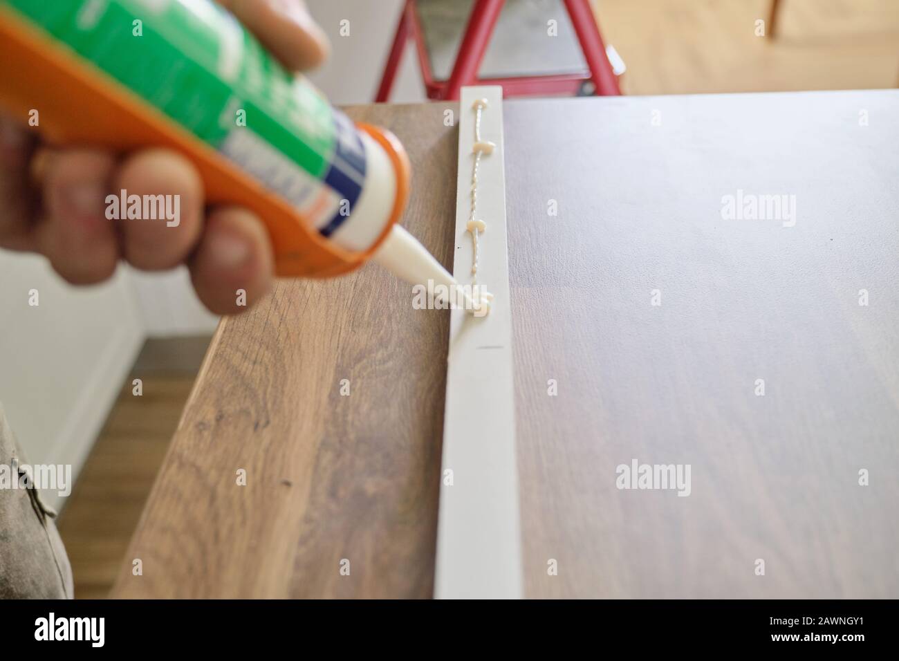 Carpenter male using construction glue when working with wooden board Stock Photo