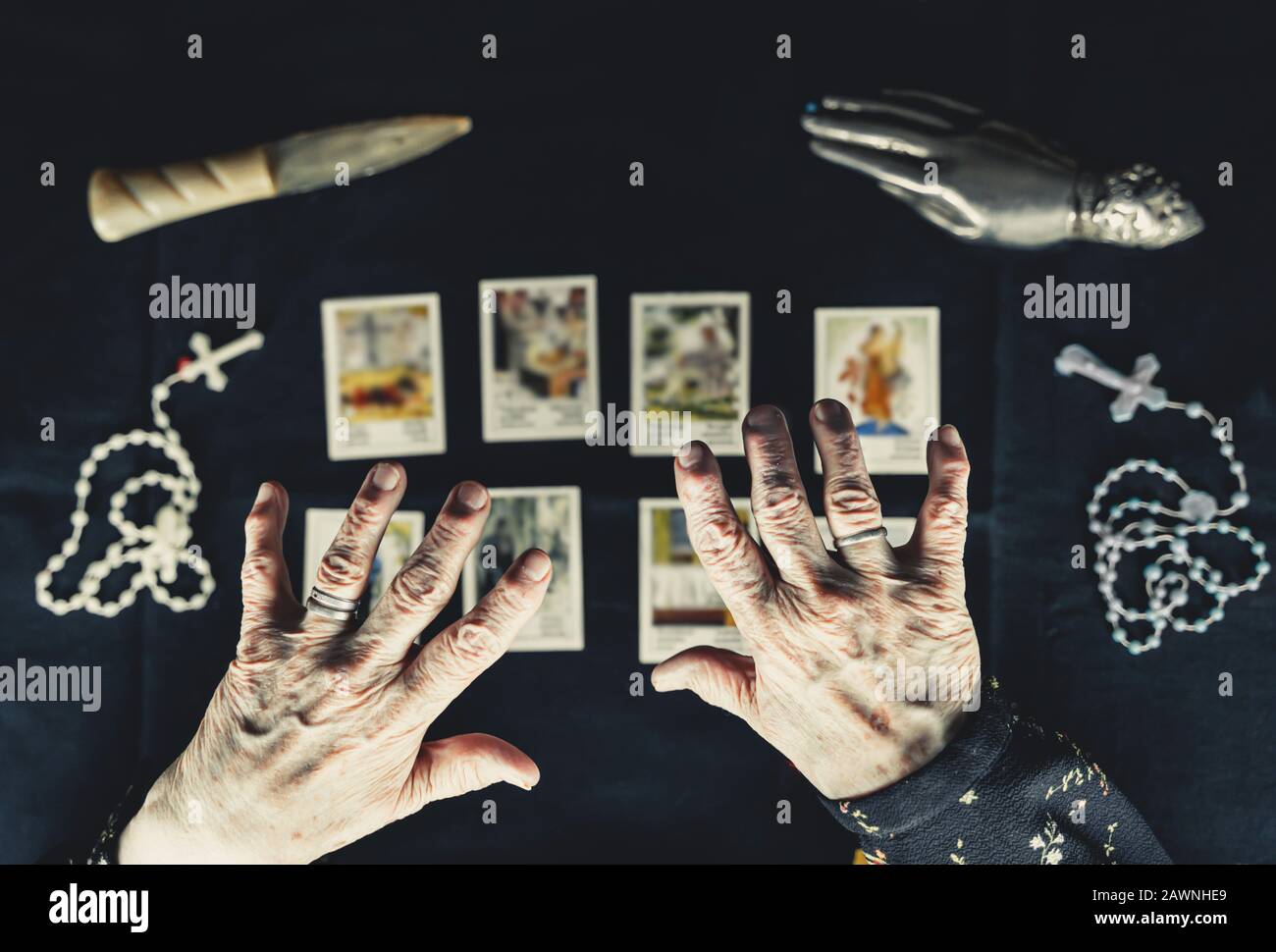 Old woman holding her hands above tarot cards. Old wrinkeld hands. Occult fortune telling concept. Picture taken from above. Stock Photo