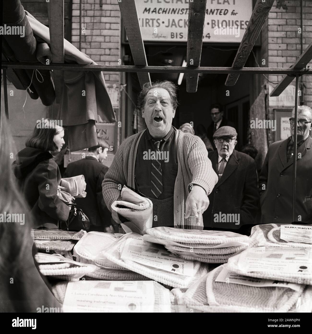 Brisk business at the Petticoat Lane Market in east London. The man is selling covers for toilet seats. Stock Photo