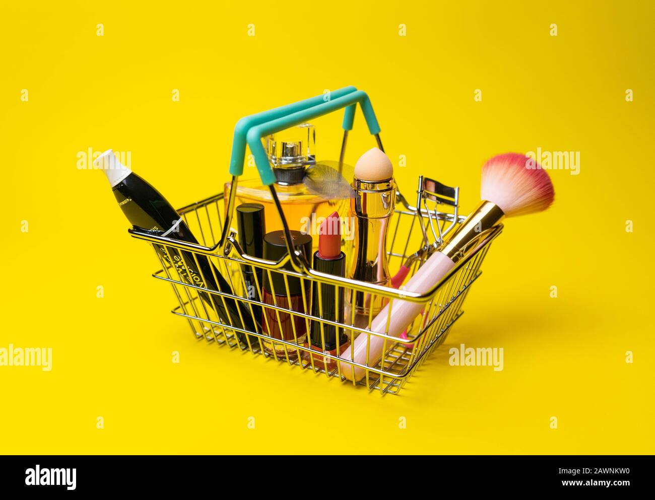 Makeup products fondant, mascara, perfume, brush, with cosmetic bag shopping cart on color background Stock Photo