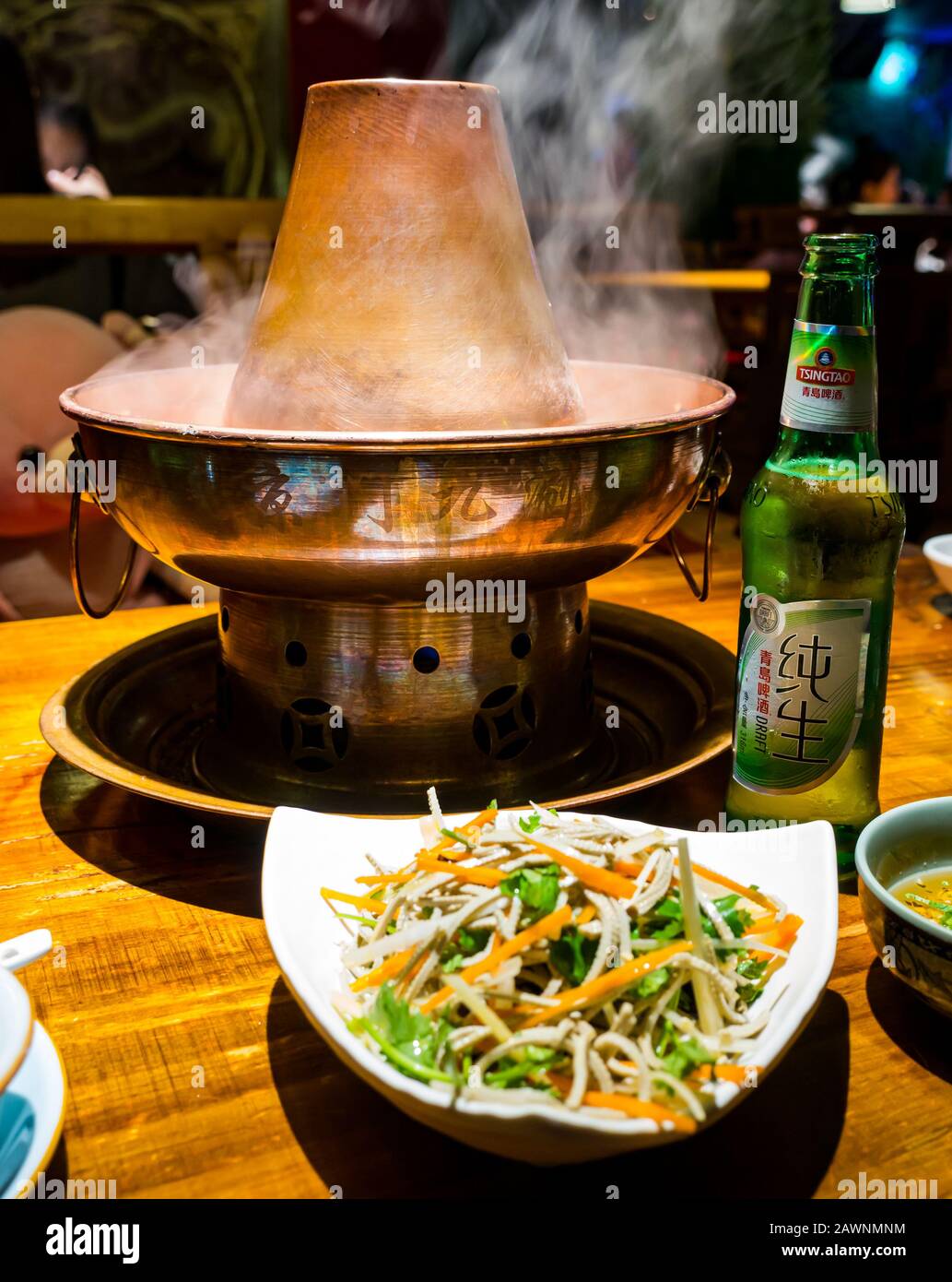 Mongolian hotpot served at table in restaurant with local Tsingtao beer, Xi Cheng Hutong District, Beijing, China, Asia Stock Photo