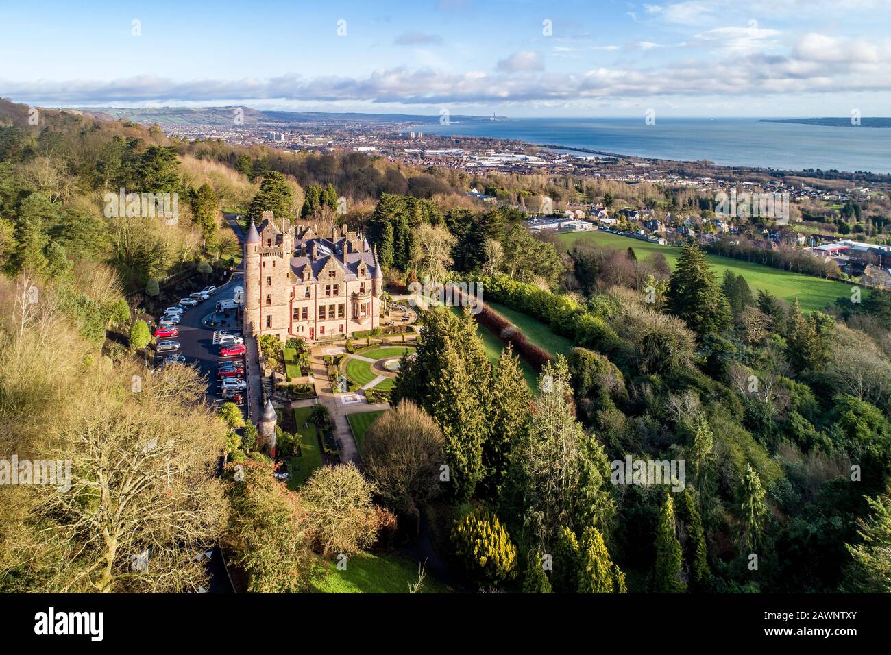 Belfast castle. Tourist attraction on the slopes of Cave Hill Country Park in Belfast, Northern Ireland. Aerial view. Belfast Lough and city in the ba Stock Photo