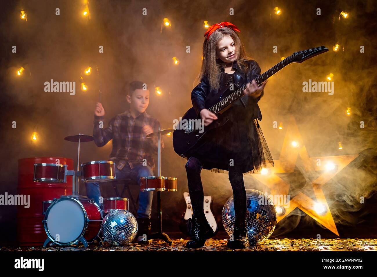 Kids pretending to be in a rock band and play and sing at studio or