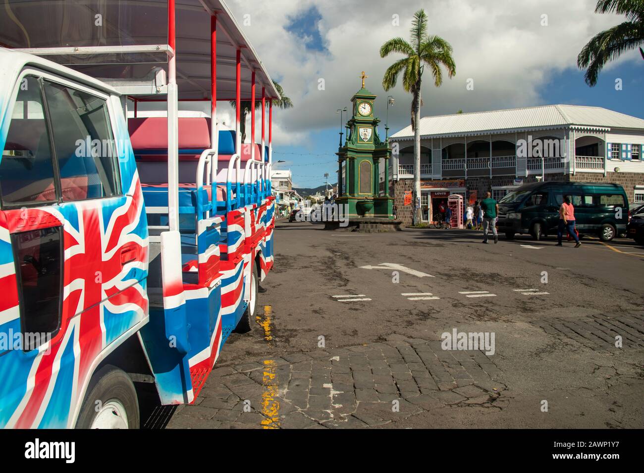 Basseterre, Saint Kitts - January 24, 2020:  Colorful tour bus near clock tower in Basseterre, Saint Kitts. Stock Photo