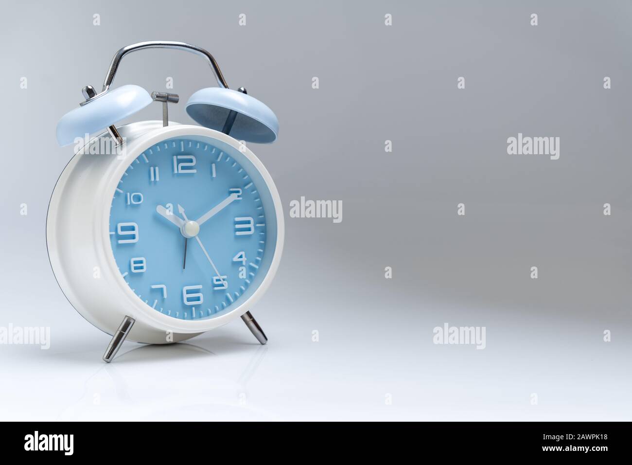 Old fashioned alarm clock on white background Stock Photo - Alamy