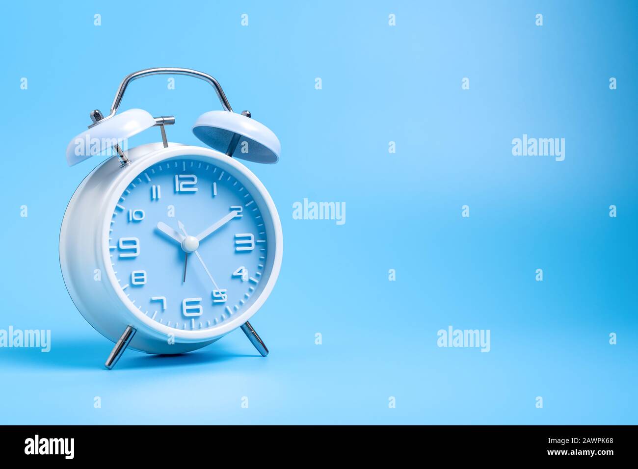 Old fashioned alarm clock on blue background Stock Photo - Alamy