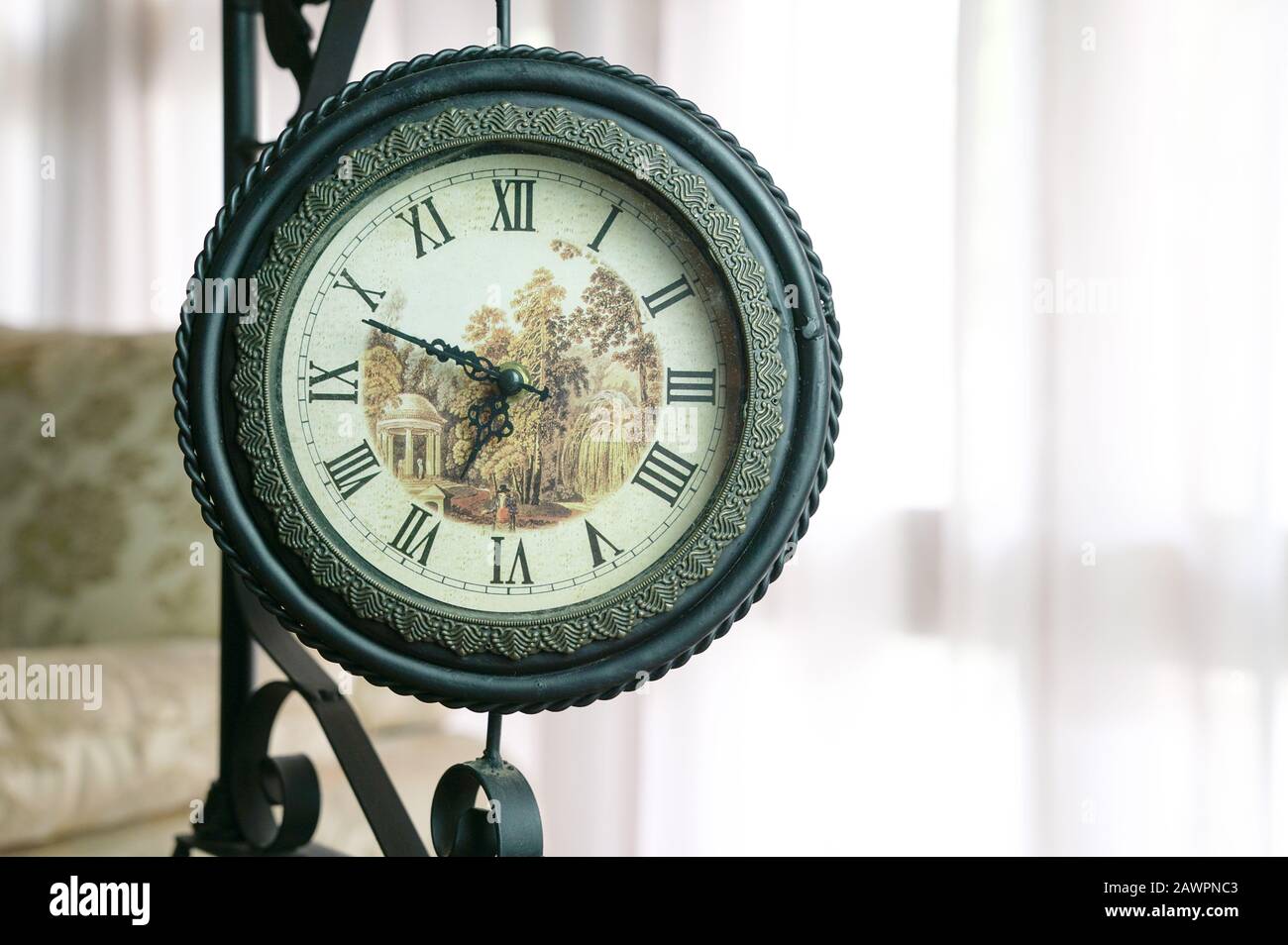 Vintage clock made of steel, inside a room. Cosy environment. Copy space. Stock Photo