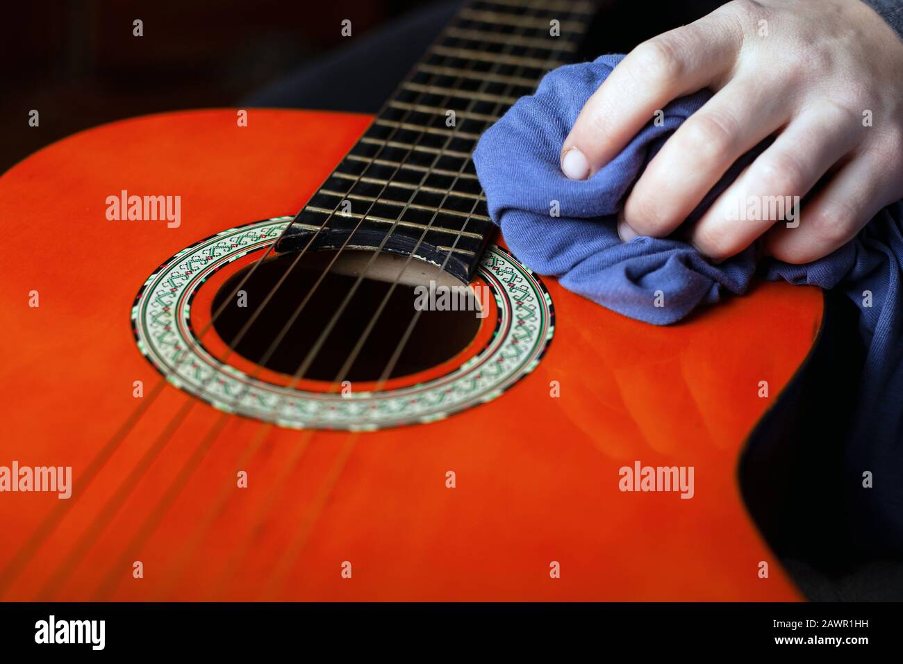 dusting the musical instrument. rub wax acoustic guitar Stock Photo Alamy