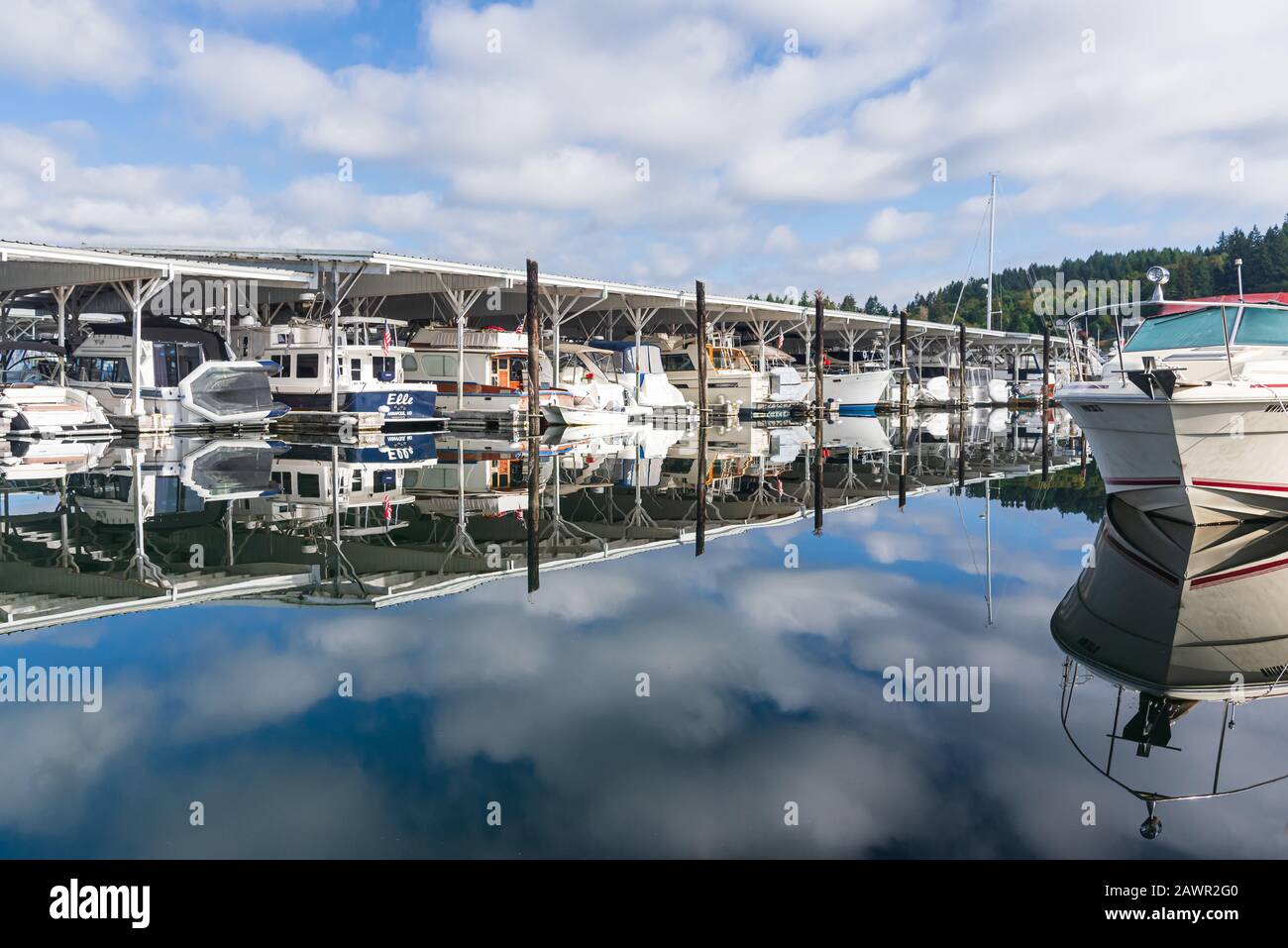 Early morning over the protected bay of Gig Harbor, Washington with blue skies and pretty white clouds Stock Photo