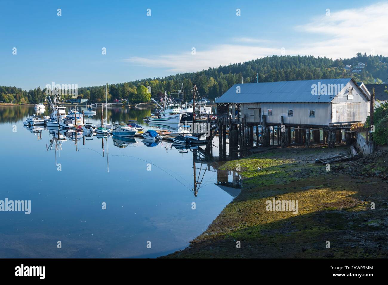 Early morning over the protected bay of Gig Harbor, Washington with blue skies and pretty white clouds Stock Photo