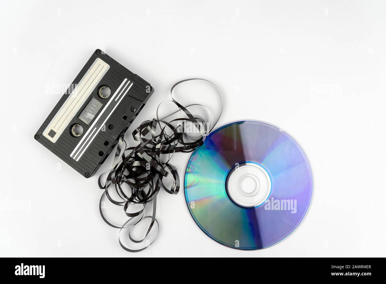 High angle shot of a cassette and a black tape put in front of a CD disk Stock Photo