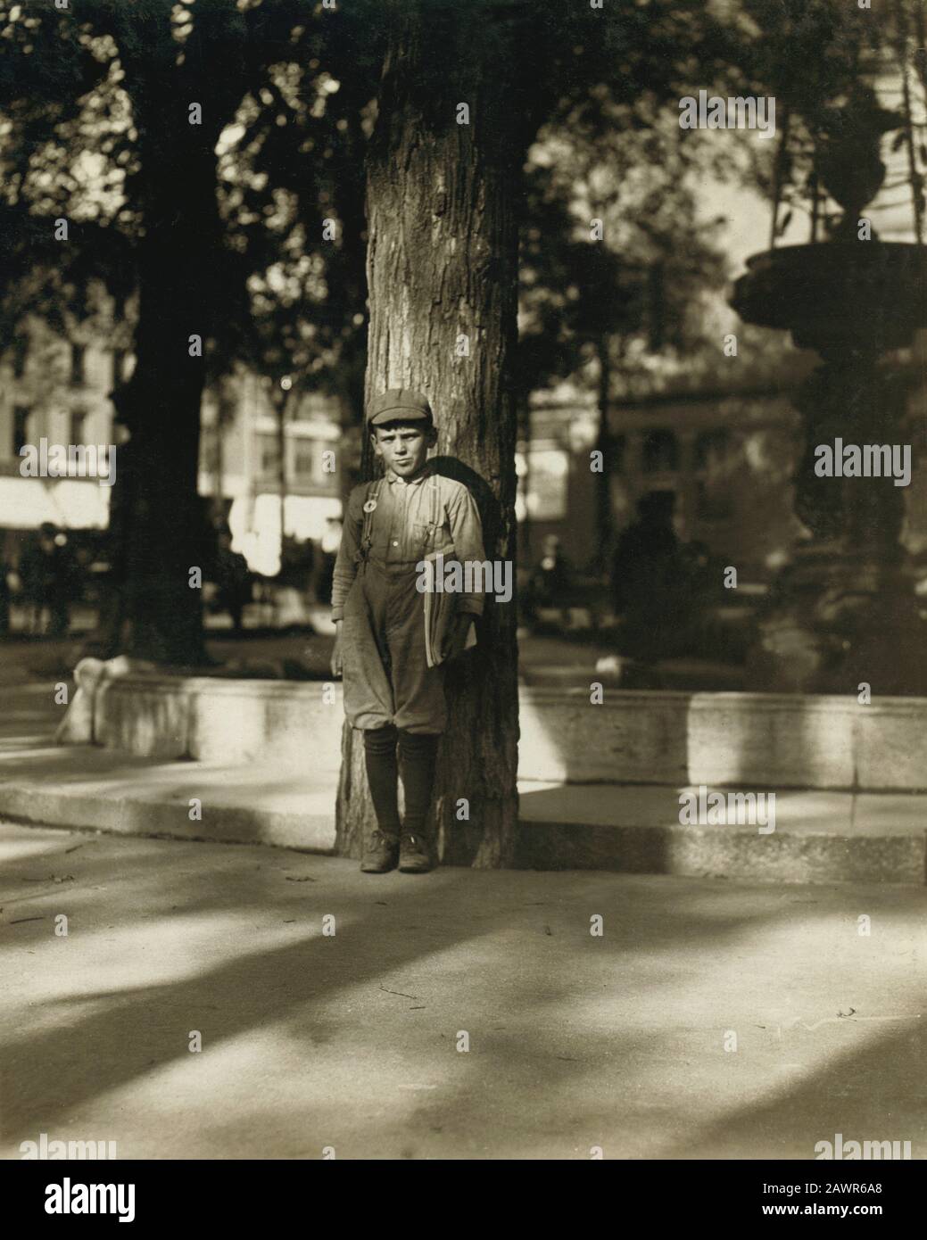 1910 , september, Burlington, Vermont, USA  : Newsboy in Park. Burlington, Vt.  - NEWSBOYS  , Photos by LEWIS HINE ( 1874 - 1940 ) -  - BAMBINI -- LAV Stock Photo