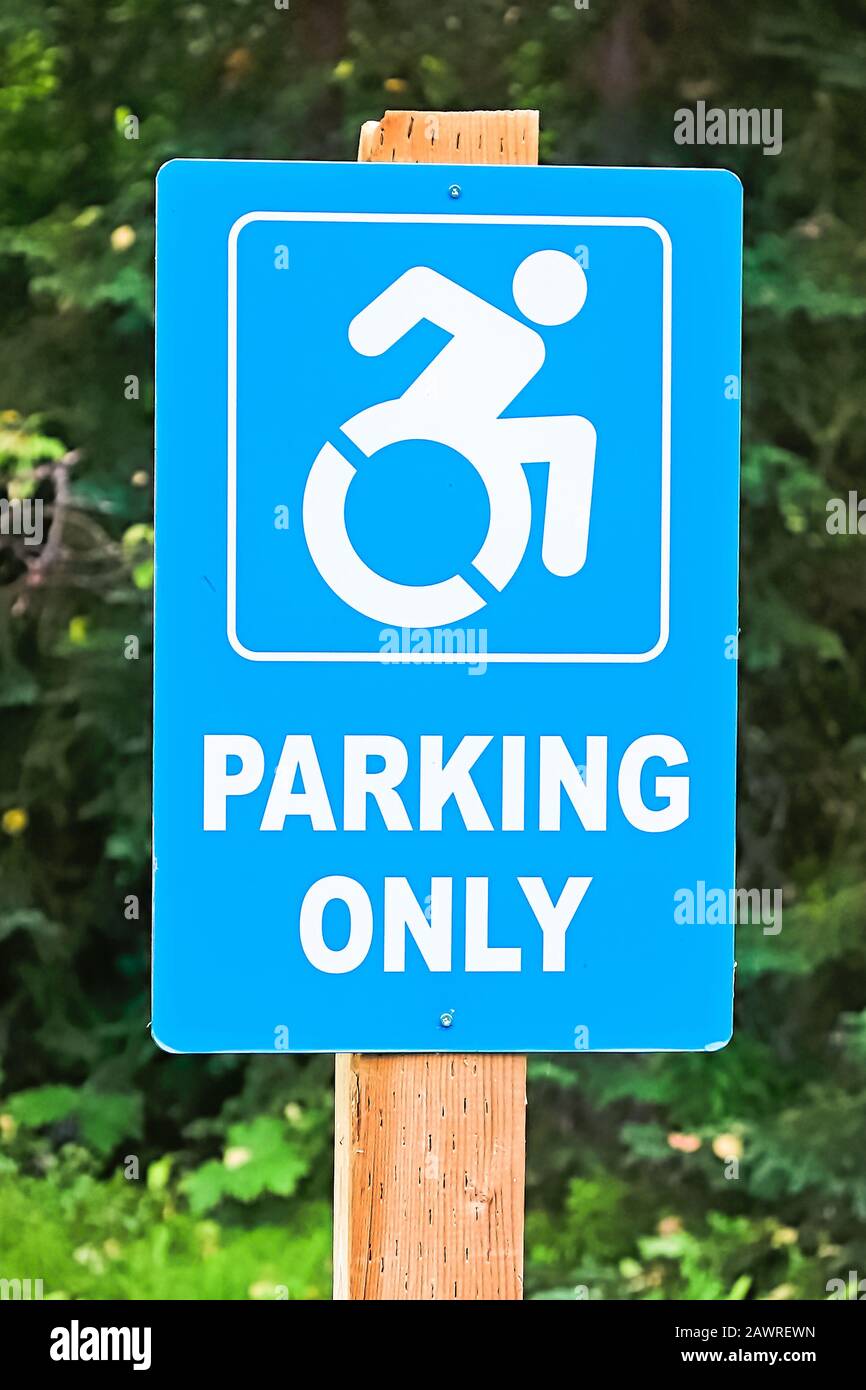 A blue handicap parking only sign on a post Stock Photo Alamy