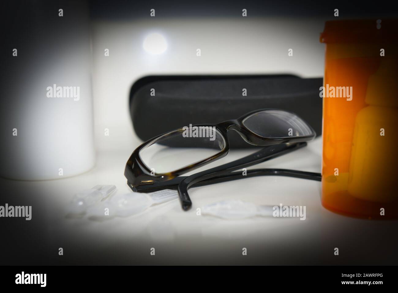 Glaucoma halo around glasses beside prescription vial. Heavy vignette simulating glaucoma vision loss Stock Photo