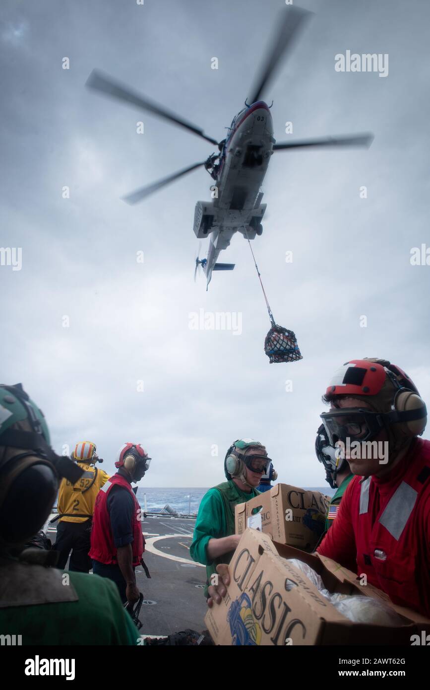 PACIFIC OCEAN (Feb. 4, 2020) U.S. Navy Sailors collect cargo aboard the Ticonderoga-class guided-missile cruiser USS Bunker Hill (CG 52) from a Eurocopter AS332 Super Puma, assigned to the dry cargo and ammunition ship USNS Carl Brashear (T-AKE 7), during a vertical replenishment-at-sea Feb. 4, 2020. Bunker Hill, part of the Theodore Roosevelt Carrier Strike Group, is on a scheduled deployment to the Indo-Pacific. (U.S. Navy photo by Mass Communication Specialist 3rd Class Nicholas V. Huynh) Stock Photo