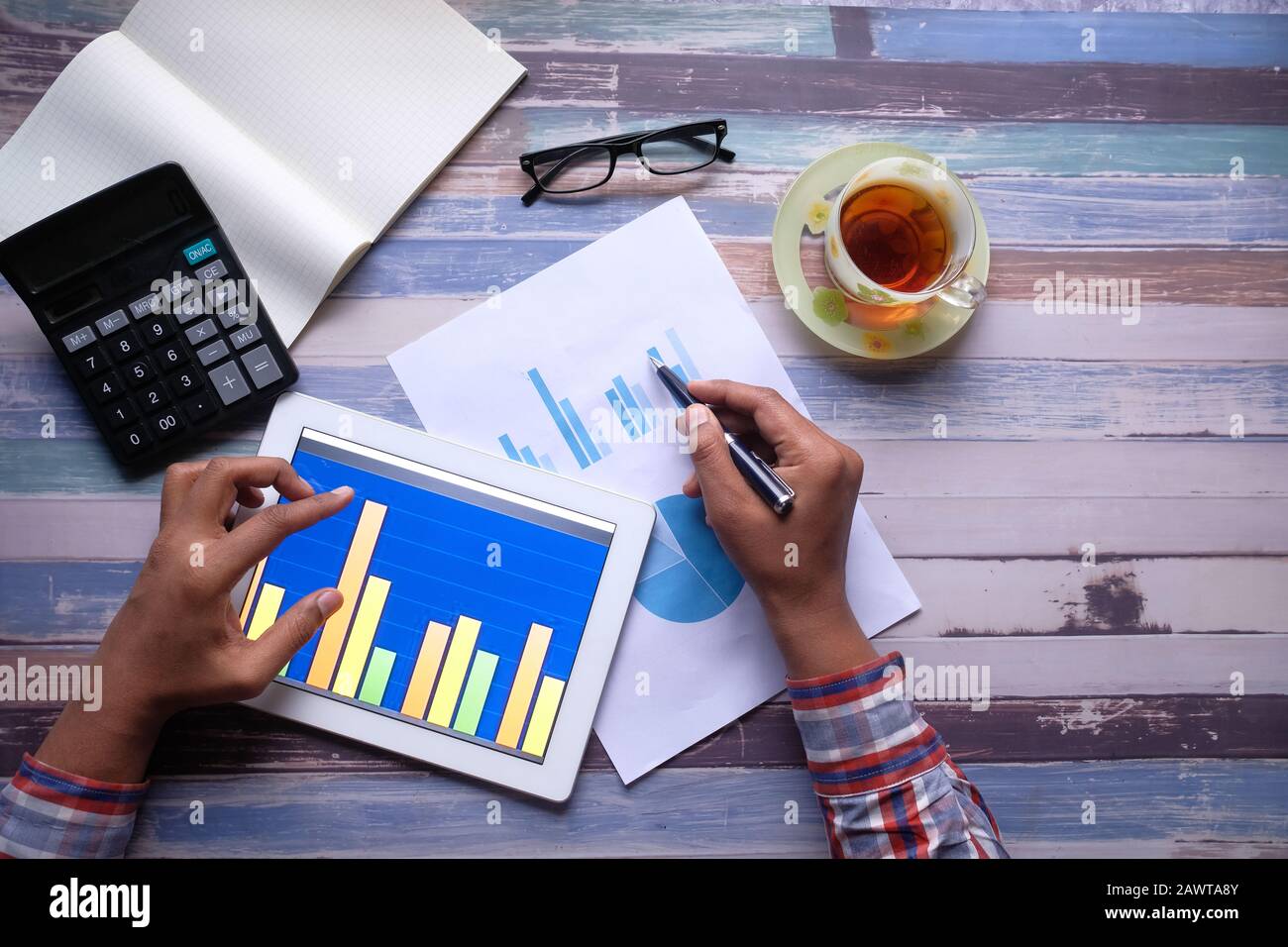 Closeup of man analyzing chart on digital tablet Stock Photo