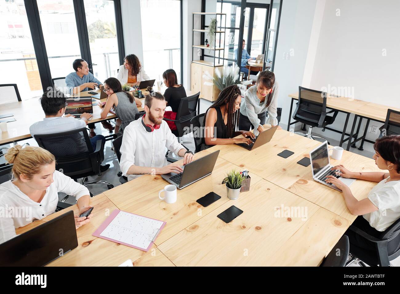 Open space office with software developers, designers and managers working on various projects Stock Photo