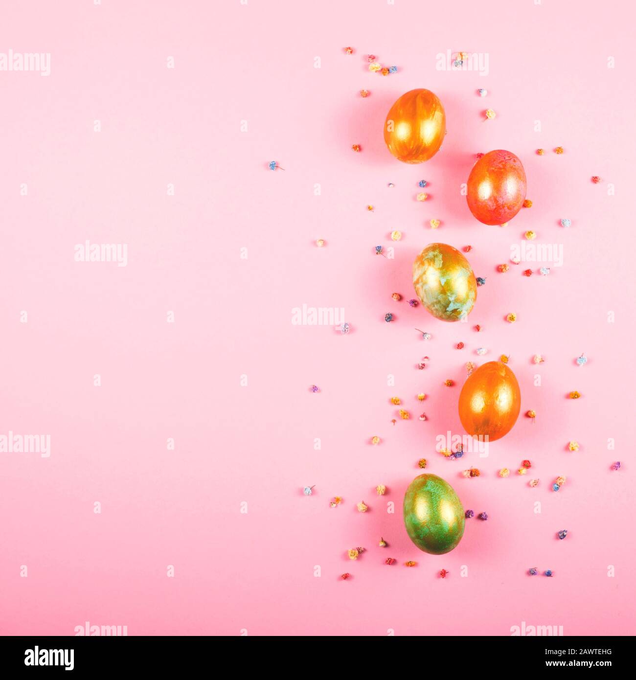 Beautiful painted easter eggs and small flowers on a pink Easter