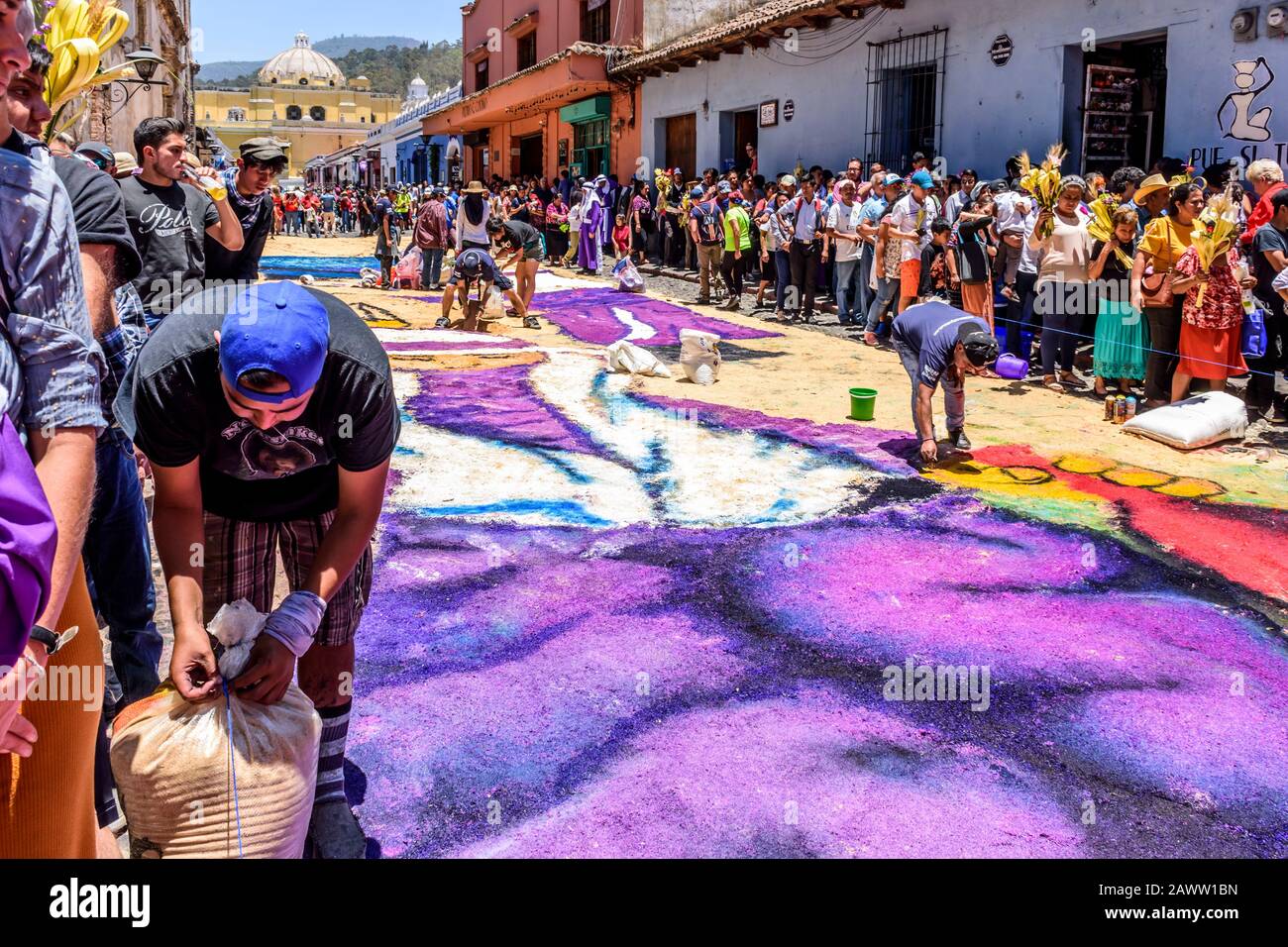 Antigua, Guatemala -  April 14, 2019: Tourists watch making of dyed sawdust Palm Sunday procession carpet in UNESCO World Heritage Site. Stock Photo