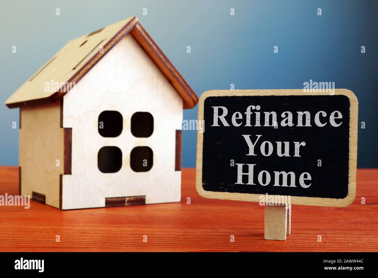 Refinance Your Home mortgage board and wooden house. Stock Photo