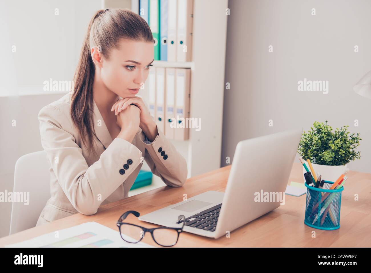 Portrait of ponder woman with laptop thinking about problem on work Stock Photo