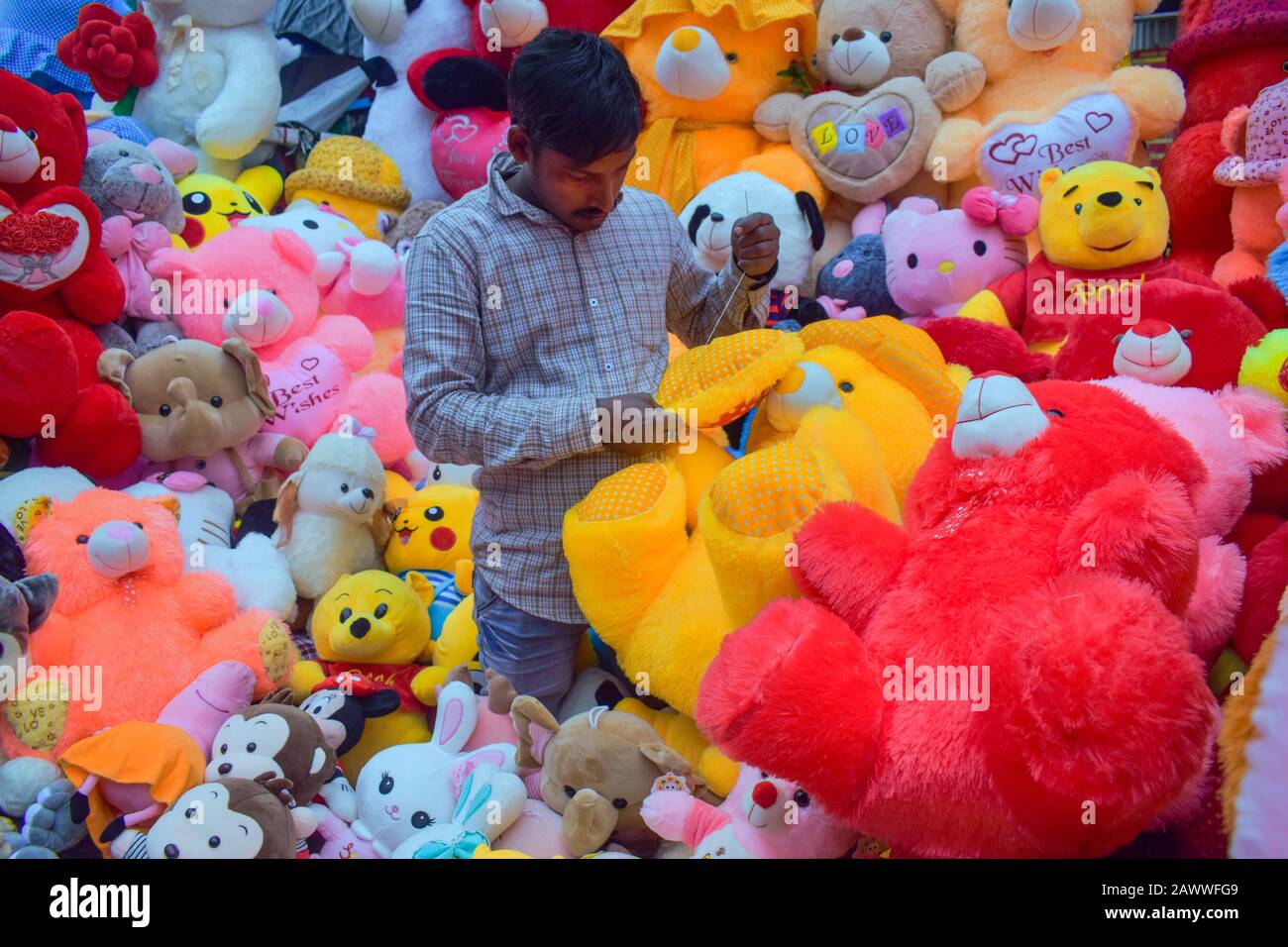 A man is making teddy bears on his shop in Kolkata, India. Stock Photo