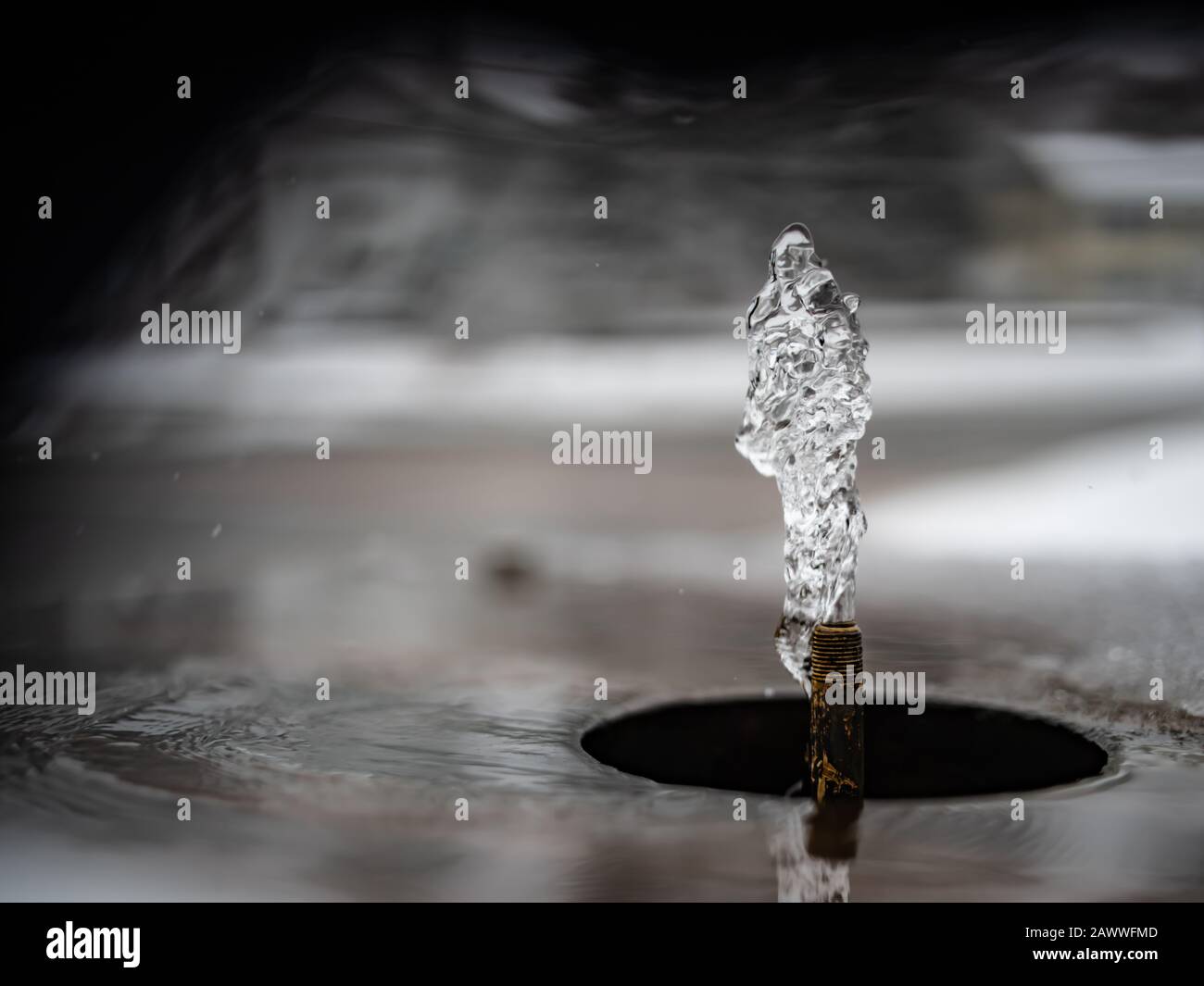Water Erupts From a Small Spigot With a Beautiful Background Stock Photo