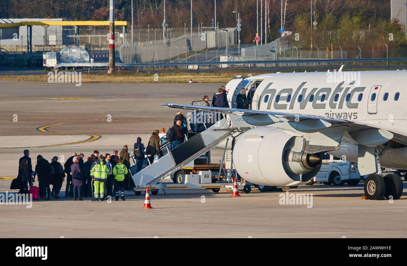 Hannover, Germany, February 8., 2020: Passengers climb stairs to the cockpit of the Helvetic Airways aircraft from Switzerland Stock Photo